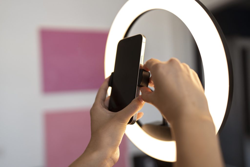 Person med telefon og ringlight klar til at lave content til TikTok Ads