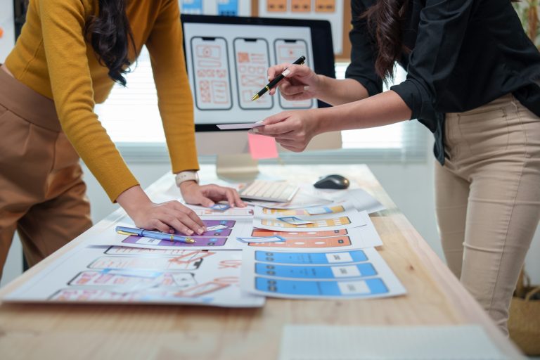 To medarbejdere planlægger markedsføring for sin virksomhed med farverige UX og UI design