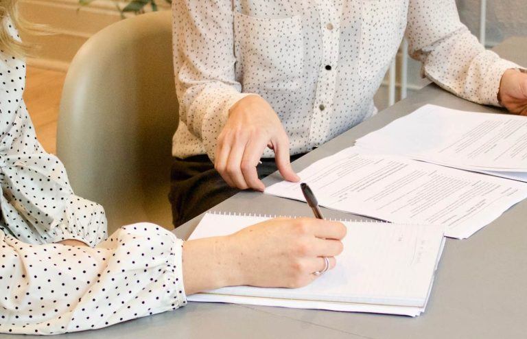 Personer sidder med papirer og noterer