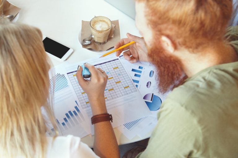 to medarbejdere laver Ideal customer profil (ICP) på skrivebord med blyant og pen i hånden
